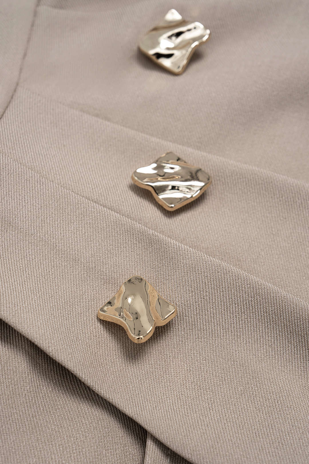 Sculptural gold-tone buttons on the beige corset of the Milan Beige Top