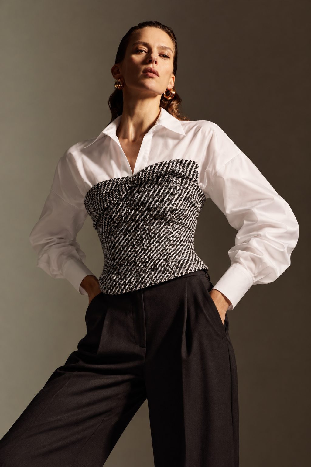 Model wearing the Versailles top, a white shirt with black-and-white tweed corset, from The Layover by Revelle